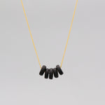 Gold necklace with black disk beads