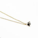 Gold necklace with a triangular caged charm