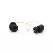 Gold hoop earrings with black disk beads