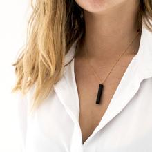 Gold necklace with a black bar pendant