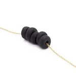 Gold necklace with black disk beads