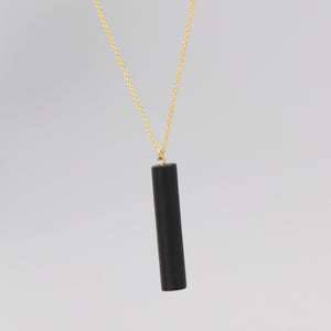 Gold necklace with a black bar pendant