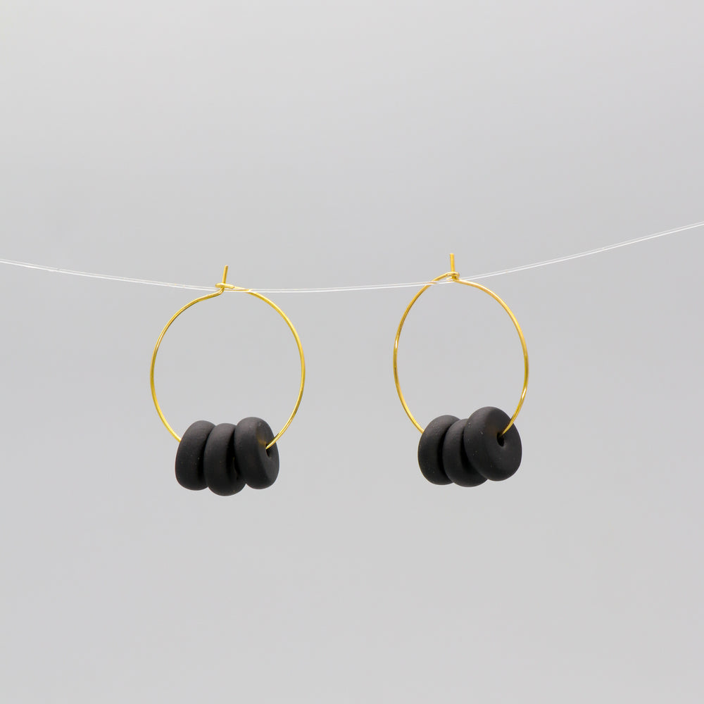 Gold hoop earrings with black disk beads