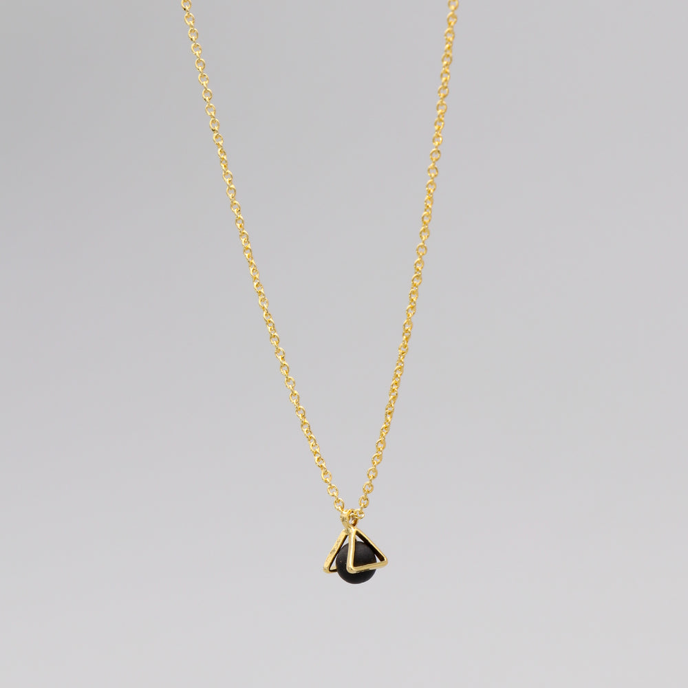 Gold necklace with a triangular caged charm
